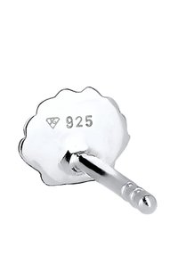 Silvrig öronhänge bakdel med vågig kant, märkt "925" för silverinnehåll, med en slät, glänsande yta och en rak pinne.