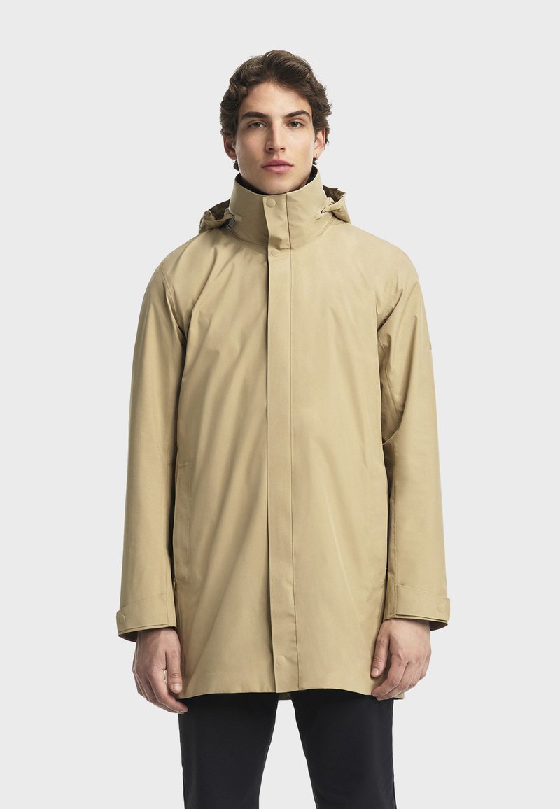 Beige wasserdichte Jacke mit hohem Kragen, langen Ärmeln und seitlichen Taschen. Glatte Textur mit Knopf- und Reißverschluss.