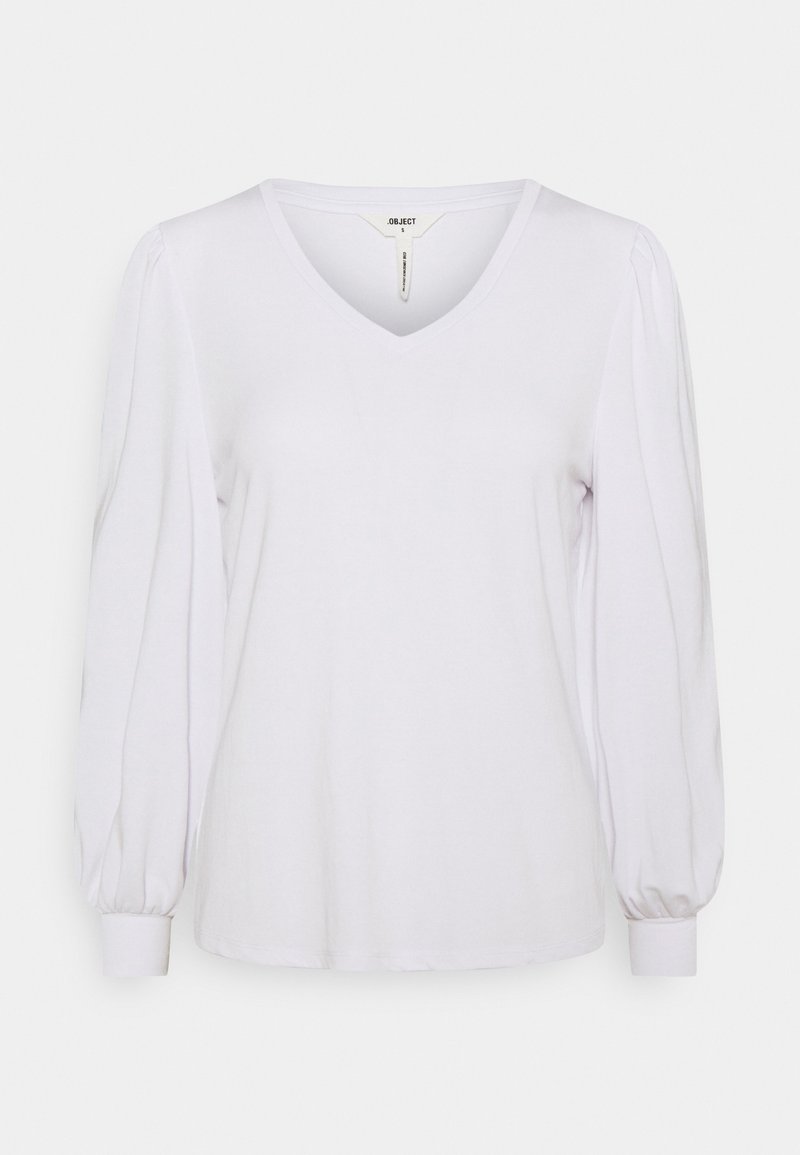 Vit långärmad topp i bomullsblandning, med V-ringning och puffärmar med åtsittande manschetter. Slät textur och avslappnad silhuett.