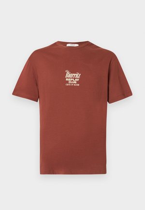 Kortermet rustfarget bomulls-T-skjorte med hvit trykt logo "the Biarritz Replay Club Cote d'Azur" på brystet.