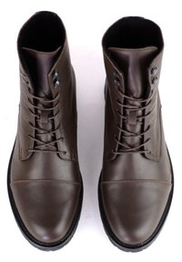 Braune Leder-Ankle-Boots mit runden Zehen, schlankem Design, Schnürverschluss und strukturierten Gummisohlen; enthalten sind Metall-Ösen und Nähdetails.