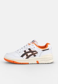 Baskets blanches avec accents noirs et détails orange. Dotées d'une tige en cuir lisse, d'une zone d'orteil perforée et d'un logo sur le côté. Semelle en caoutchouc.