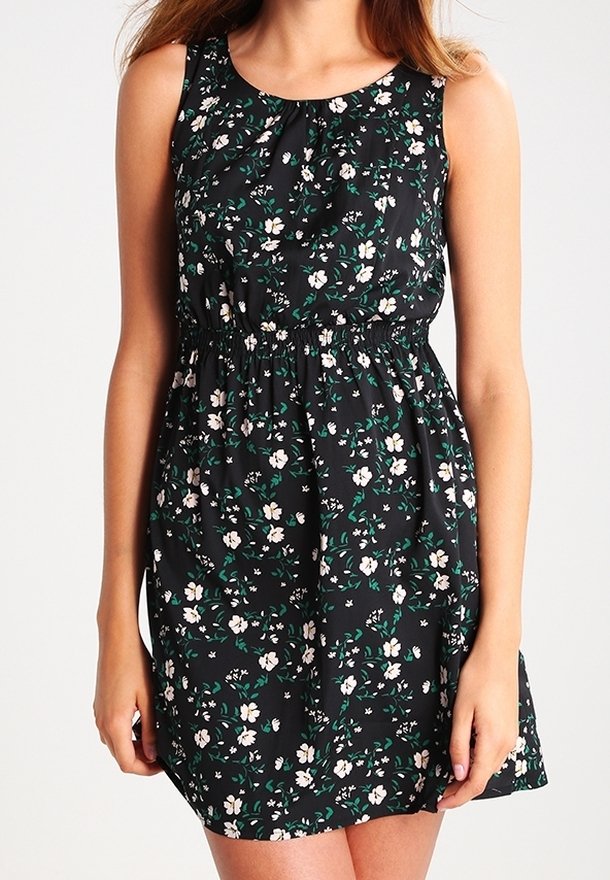 Vestido floral con fondo negro, que presenta flores blancas y verdes, diseño sin mangas, cintura elástica y textura de tela suave.