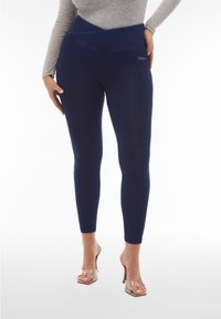 Leggings blu navy con un alto bordo piegato in vita e una vestibilità slim, realizzati in un materiale elastico. Presentano un branding minimale sull'anca.