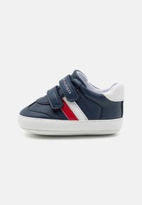 Navy modré tenisky pro batolata vyrobené z umělé kůže, s bílými a červenými pruhy, suchým zipem a bílou gumovou podešví.