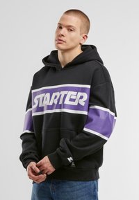 Black hoodie with purple and white stripes featuring the "STARTER" logo across the chest. Solid color, soft fabric, and a kangaroo pocket.