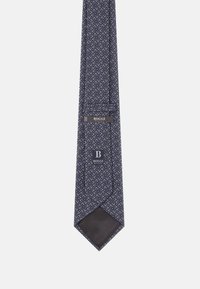 Cravatta blu navy con un dettagliato motivo a spirale bianco e rosso. Tessuto liscio con una punta nera unita e un'etichetta di marca che riporta "BOGGI."