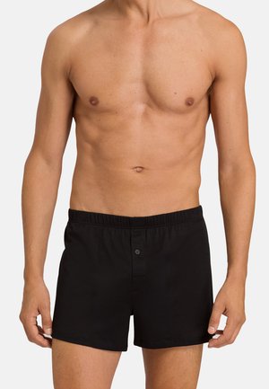 Schwarze Baumwoll-Boxershorts mit elastischem Bund, Frontknopfverschluss und Seitentaschen. Einfaches Design, glatte Textur und taillierte Passform.