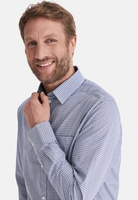 Karierte blau-weiße Langarmbluse mit Kragen, Knopfleiste und einer Brusttasche. Weicher Stoff und lässige Passform.