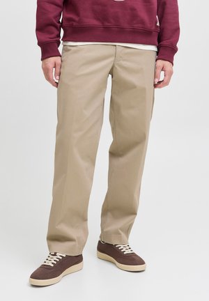 Beige chinos met een rechte snit, gemaakt van een katoenmix. Gecombineerd met bruine sneakers met witte veters en een gestructureerde stof.