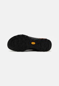 Melnā zole ar dziļiem, daudzvirzienu uzgaļiem, kas nodrošina saķeri. Vibram logo dzeltenā krāsā tuvu papēžam. Gluda gumijas virsma ar izturīgu dizainu.