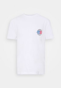 Bílá tričko s krátkým rukávem a malým kulatým logem na levém hrudníku, obsahující modrou, červenou a bílou barvu s nápisem "Tommy."