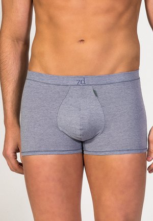 Bóxer gris con una tela suave y elástica. Presenta un bolsillo frontal y un logo en la cinturilla. Diseño simple con costuras planas.