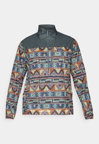 Multifarvet pullover-jakke med et geometrisk mønster, høj krave og kvart-zip foran. Lavet af letvægtsstof.