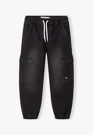 Čierne denimové cargo nohavice s elastickým pásom, nastaviteľným šnúrkou a manžetami na leme. Obsahujú viacero vreciek a opotrebovaný vzhľad.