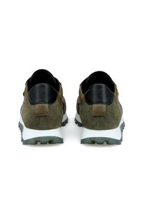 Sneaker in camoscio verde con dettagli in pelle nera, dotate di una suola intermedia bianca e una suola in gomma testurizzata. Linguetta sul tallone in marrone.