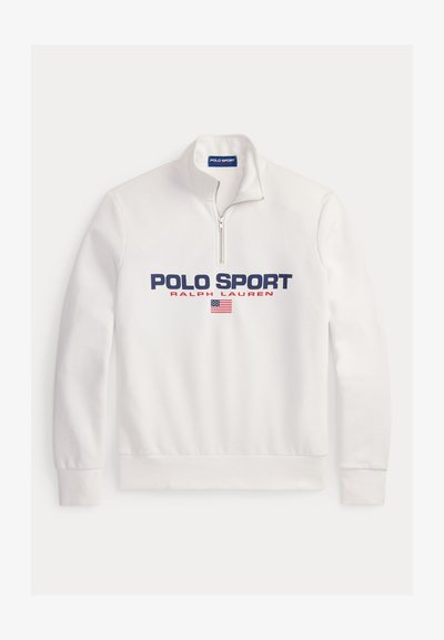 Balts pulovers ar kvartāla rāvējslēdzēju, ar lielu "POLO SPORT" logotipu zilā un sarkanā krāsā, kā arī nelielu Amerikas karoga detaļu.