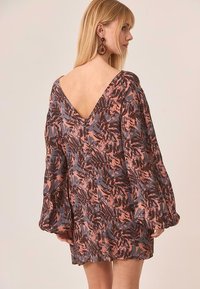 Vestido con estampado floral, con un profundo escote en V en la parte de atrás, mangas largas abullonadas y una silueta suelta. Los tonos de color incluyen rosa, marrón y azul.