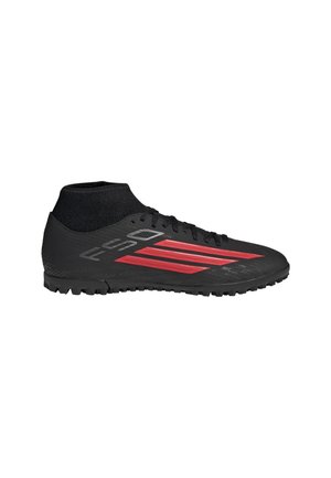 Scarpa da calcio Adidas nera e rossa con collo a calza alla caviglia e suola testurizzata per superfici in erba sintetica o campi in erba artificiale.