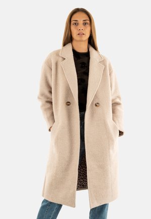 Cappotto beige in misto lana con ampio risvolto, bottoni doppi, tasche laterali e finitura testurizzata; presenta una fodera con stampa leopardata.