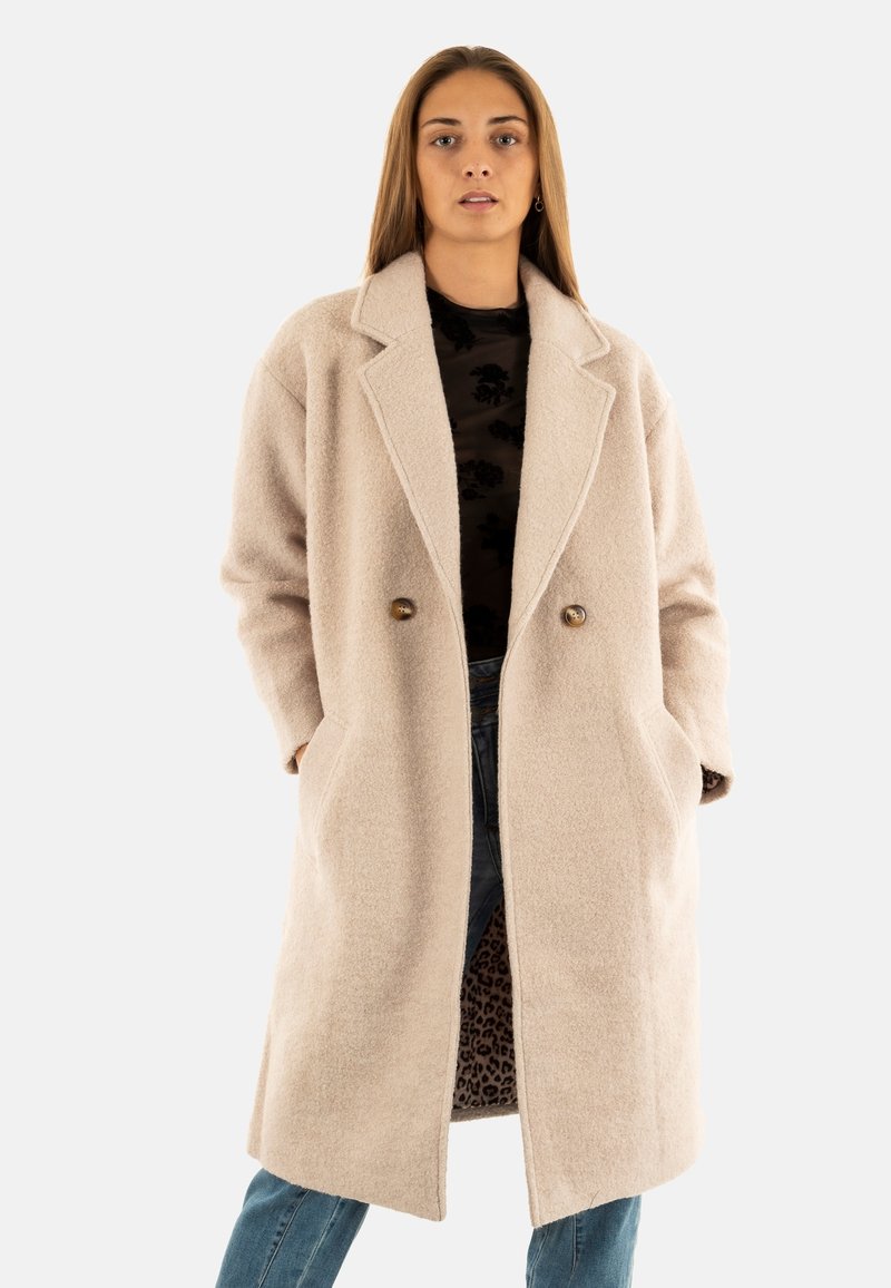 Abrigo de mezcla de lana beige con solapas anchas, doble botonadura, bolsillos laterales y un exterior texturizado; cuenta con un forro de estampado de leopardo.