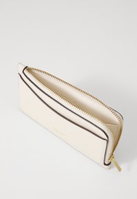 White leather wallet with gold zipper and brown accents. Features a slim design and embossed logo on the front, showcasing clean lines.