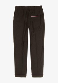 Czarne spodnie z elastycznym paskiem w talii, z jedną tylną kieszenią w poziome białe i czerwone paski. Gładki materiał z zwężanymi nogawkami.