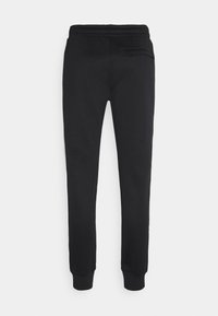 Černé tepláky z měkké látky, se strečovým pasem, zúžené nohavice a jednou zadní kapsou. Hladká textura bez vzorů.