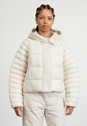 Φούτερ σε ανοιχτό κρέμ χρώμα με κουκούλα, που διαθέτει ραμμένο υλικό, πλισέ μπροστινό πάνελ και σφιχτά μανίκια. Συνδυάζεται με αντίστοιχες ραμμένες παντελόνες.