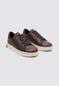 Zapatillas de cuero marrón con un acabado texturizado, puntera redonda, cordones en tono a juego y una suela de goma beige contrastante para mayor comodidad.