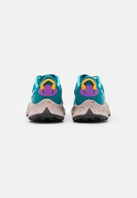 Teal og lilla sportsko med en tekstureret pink sål, der har en farverig hælsløjfe og mesh-overdel for åndbarhed.