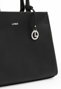 Bolso de mano sintético negro con un acabado texturizado, que presenta un detalle de logo plateado y un charm circular adjunto al asa.