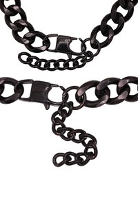 Collana in metallo nero con catena caratterizzata da anelli spessi con finitura lucida, dotata di chiusura a moschettone e una catena aggiuntiva più piccola.