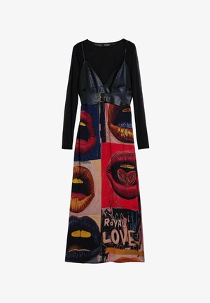 Zwarte top met lange mouwen en een cropped top van nepleer, gecombineerd met een kleurrijke rok met grafische lippen en de tekst "Royal Love".