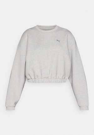 Hellgrauer, verkürzter Pullover mit geripptem Saum, überschnittenen Schultern und kleinem schwarzem Puma-Logo auf der Brust. Weiche Stoffoberfläche.