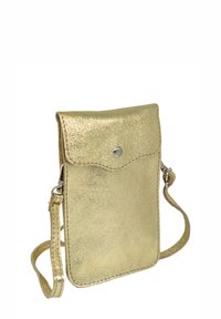 Pochette pour téléphone métallique dorée avec fermeture à rabat et bouton-pression, équipée d'une bandoulière amovible et d'une surface à texture lisse. Forme approximativement rectangulaire.