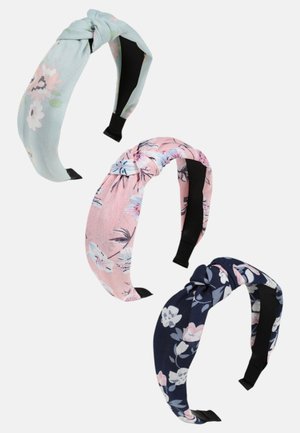 Kolme solmittua päähinettä: mintunvihreä kukkakuviolla, vaaleanpunainen kuvioilla ja tummansininen kukkaaksentteja. Kaikissa on pehmeä kangas ja mustat koot.