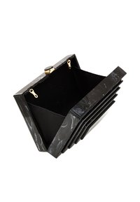 Musta marmorinen clutch, jossa on kiiltävä pinta, kultainen solki ja kangasvuoraus. Suorakaiteen muotoinen, kerroksellisilla muotoiluviivoilla.