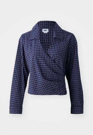 Mornarica karirana bluzica s dugim rukavima, dubokim V-izrezom i ovratnikom. Tkanina prikazuje mrežasti uzorak u nijansama plave i bijele.