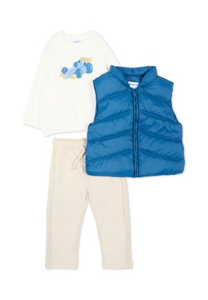 Kinderoutfit met crèmekleurige broek, wit shirt met lange mouwen met een blauwe raceauto, en een gewatteerd blauwe mouwloze bodywarmer met ritssluiting.