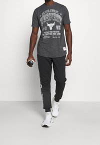 Under Armour Triko s potiskem - black