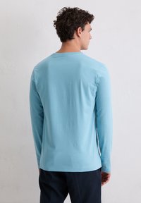 Lichtblauw shirt met lange mouwen gemaakt van zachte katoen, met een ronde hals en een losse pasvorm, een gladde textuur en zonder zichtbare patronen.