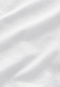Vit bomullstyg med en slät textur, med subtila veck och ett enhetligt ytmönster. Inga synliga sömmar eller utsmyckningar.
