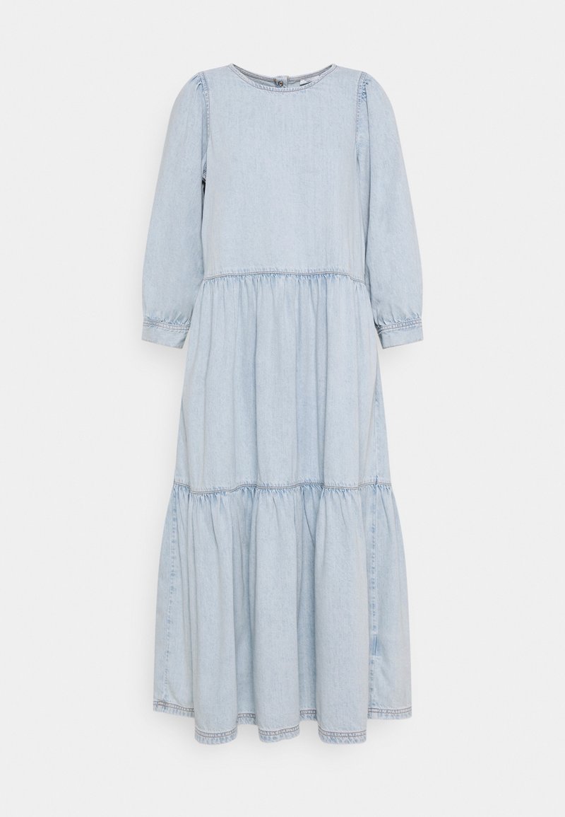 Vaaleansininen farkkumaxi-mekko, jossa on pitkät hihat, kootut vyötärönkohdan ja kerroksellinen hame. Ominaisuuksiin kuuluu pyöreä pääntie ja käännetyt hihat.