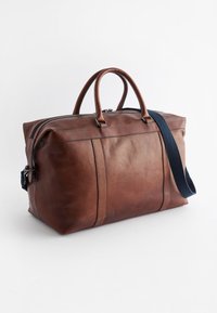 Brun læder duffel taske med tekstureret overflade, dobbelte top håndtag, aftagelig mørkeblå rem og lynlås lukning.