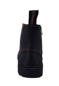 Bota negra de cuero hasta el tobillo con detalles de costura, punta redonda y asa. Cuenta con una suela de goma duradera para mayor tracción.