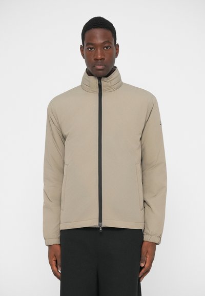 Beige leichte Jacke mit hohem Kragen, Front-Reißverschluss, zwei seitlichen Taschen und elastischen Bündchen. Glattes Material mit matter Oberfläche.
