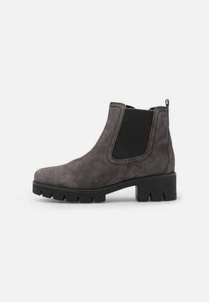 Ciemnoszare zamszowe buty Chelsea z czarną elastyczną boczną wstawką, masywną czarną podeszwą i niskim klockowym obcasem na białym tle.