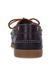 Scarpa da barca in pelle marrone con suola in gomma beige, occhielli dorati e lacci marroni. Presenta cuciture classiche lungo la parte superiore e il tallone.