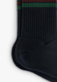 Calcetines de un oscuro tono marino con relieve, que presentan rayas verdes y burdeos en la parte superior. Textura suave con refuerzo en la zona del talón y los dedos.